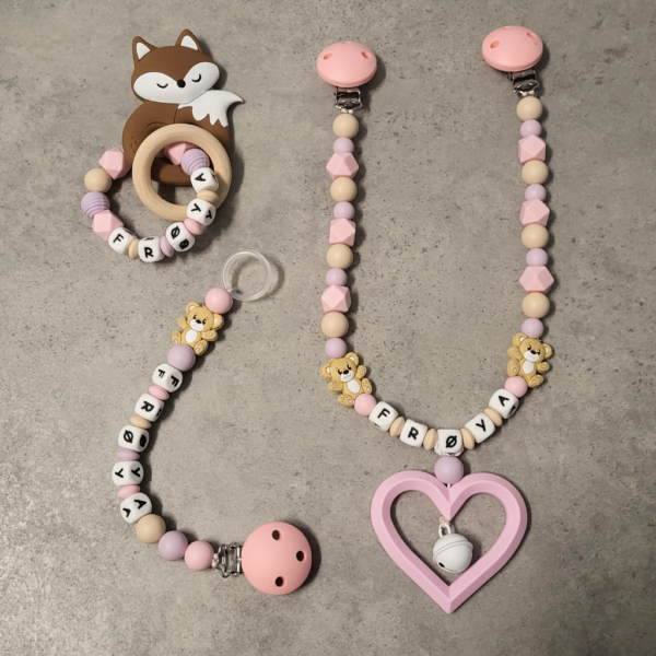 Personlig gavesett til baby med vognlenke, bitering og smokkelenke i babyrosa, beige og duse farger.